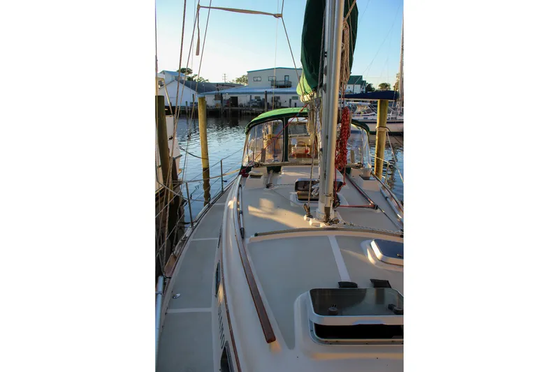 Slide: The Image of 1990 Island Packet 32 sailboat docked at marina, showcasing deck and rigging. - 5