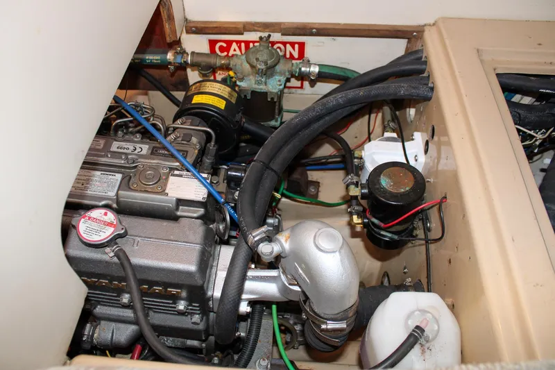 Slide: The Image of Engine compartment of a 1990 Island Packet 32 sailboat, featuring Yanmar marine engine components. - 54