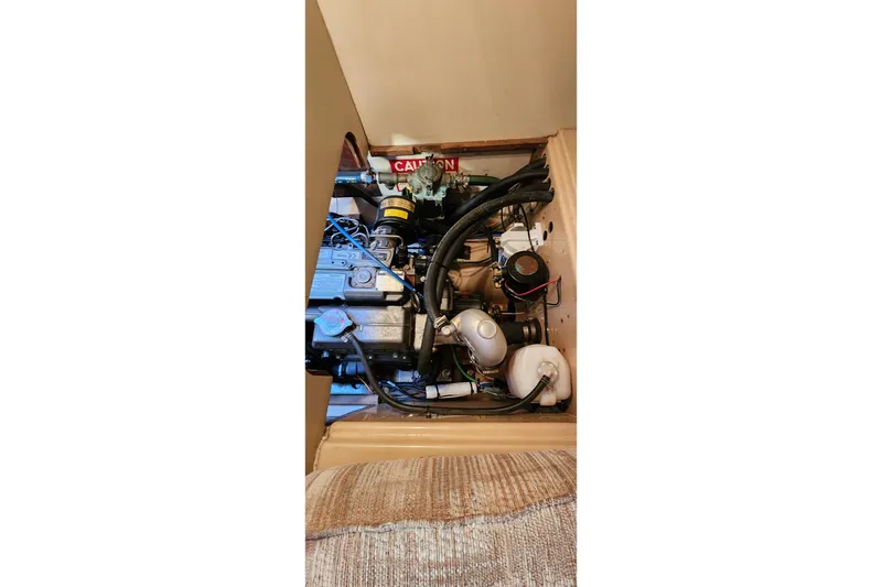 Slide: The Image of Engine compartment of a 1990 Island Packet 32 sailboat, showcasing mechanical components. - 55
