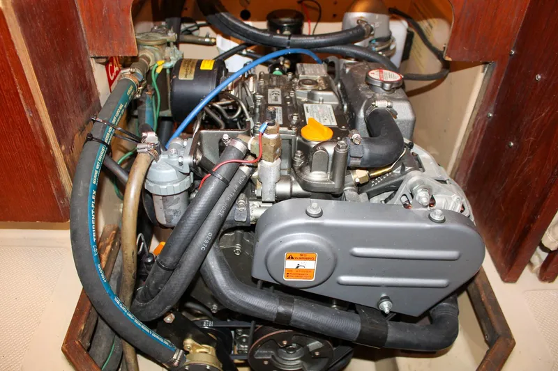 Slide: The Image of Engine compartment of a 1990 Island Packet 32 sailboat, showcasing detailed mechanical components. - 58
