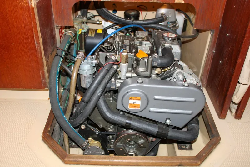 Slide: The Image of Engine compartment of a 1990 Island Packet 32 sailboat, showcasing detailed mechanical components. - 59