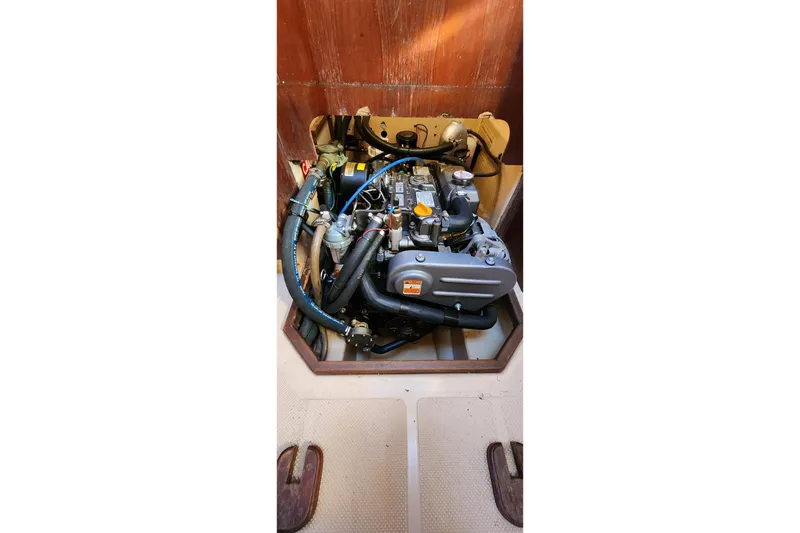 Slide: The Image of Engine compartment of a 1990 Island Packet 32 sailboat, showcasing mechanical components. - 60