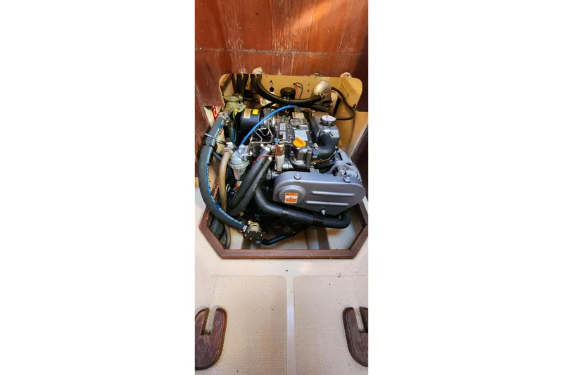 Slide: The Image of Engine compartment of a 1990 Island Packet 32 sailboat, showcasing mechanical components. - 61
