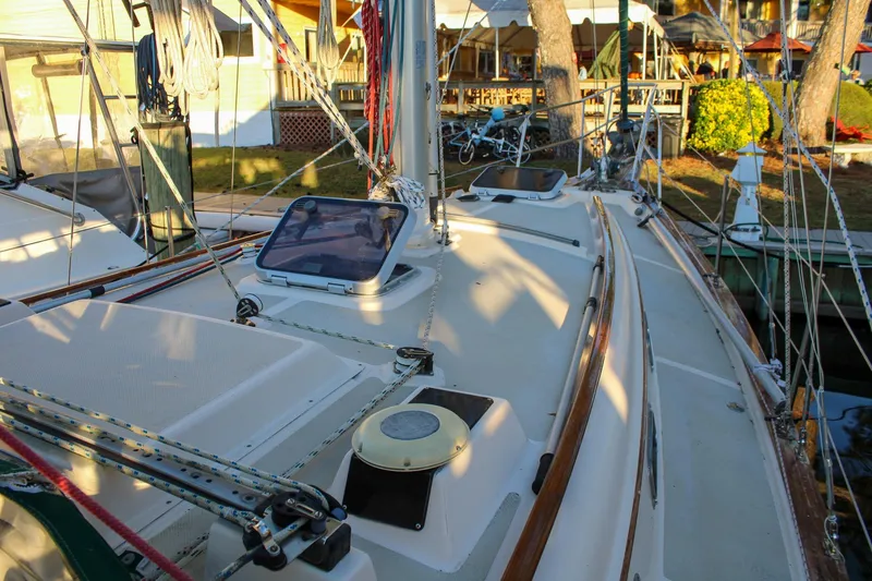 Slide: The Image of 1990 Island Packet 32 sailboat deck with rigging and hatches in marina setting. - 7