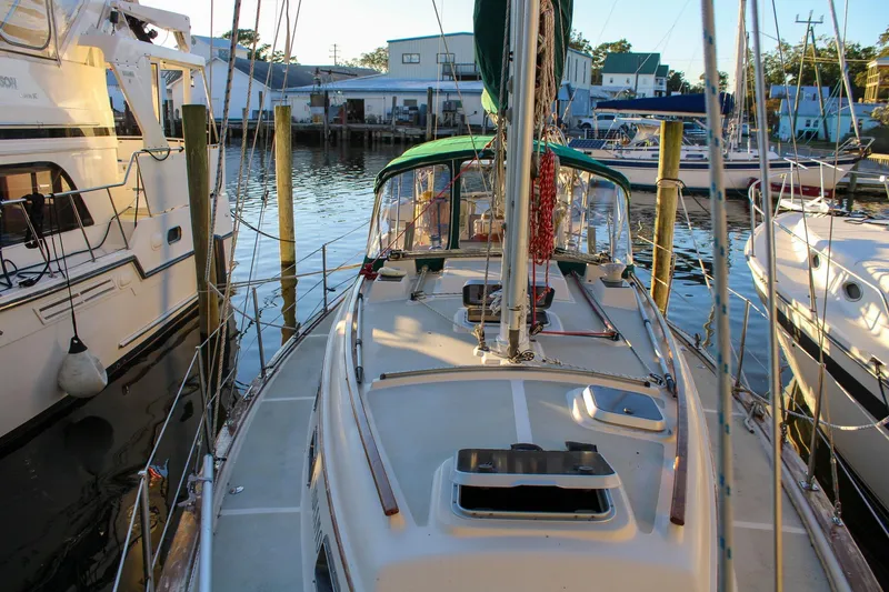 Slide: The Image of 1990 Island Packet 32 sailboat docked at marina, surrounded by other boats. - 8