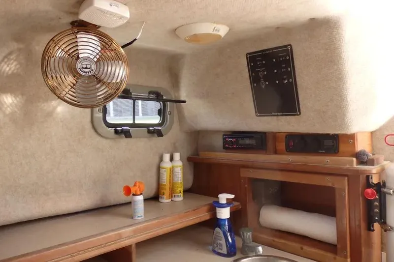 Slide: The Image of Interior of a 2001 Shamrock 26 boat with fan, cleaning supplies, and control panel. - 11