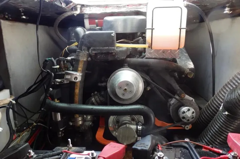 Slide: The Image of Engine compartment of a 2001 Shamrock 26 boat, showcasing mechanical components and wiring. - 14