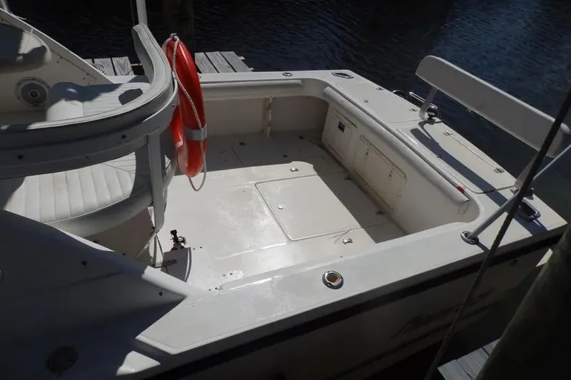 Slide: The Image of 2001 Shamrock 26 boat deck with seating and life preserver, docked by the water. - 3