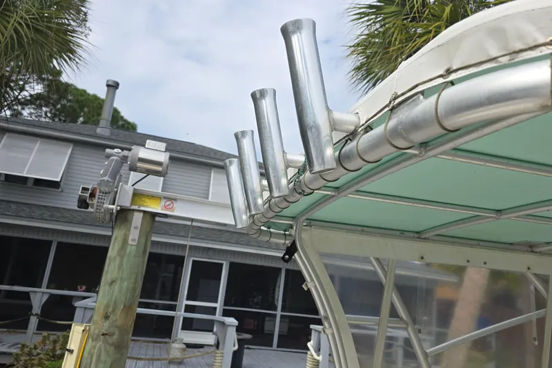 Slide: The Image of Boat canopy with rod holders on a 2001 Shamrock 26, near a dockside house. - 5