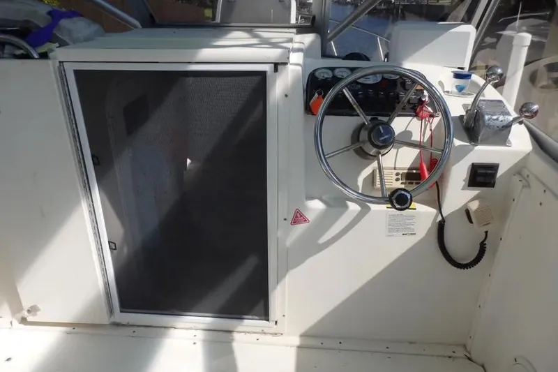 Slide: The Image of 2001 Shamrock 26 boat helm with steering wheel and control panel. - 8