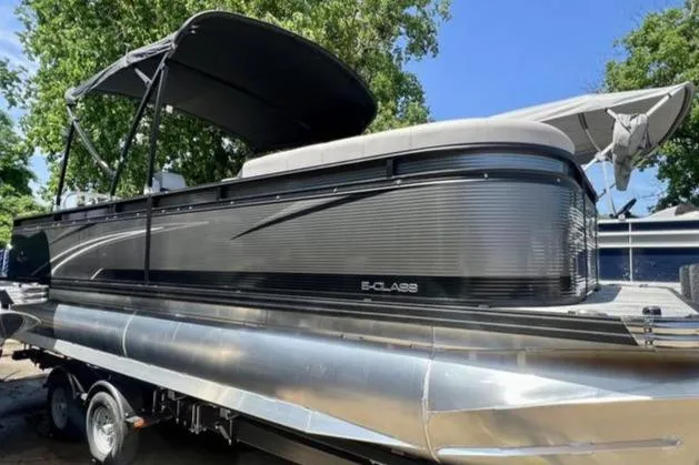 The Image of 2023 Qwest Lanai 822 pontoon boat with canopy, parked on trailer, sunny day. - 0