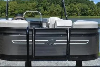 Slide: The Image of 2023 Qwest Lanai 822 pontoon boat docked by a scenic lake. - 7