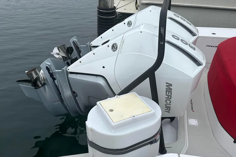 Slide: The Image of Twin Mercury outboard engines on a 2023 Axopar Brabus boat, docked in calm water. - 10