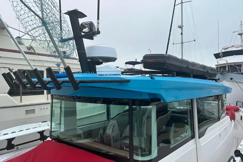 Slide: The Image of 2023 Axopar Brabus boat with blue roof, fishing rod holders, and rooftop storage. - 5