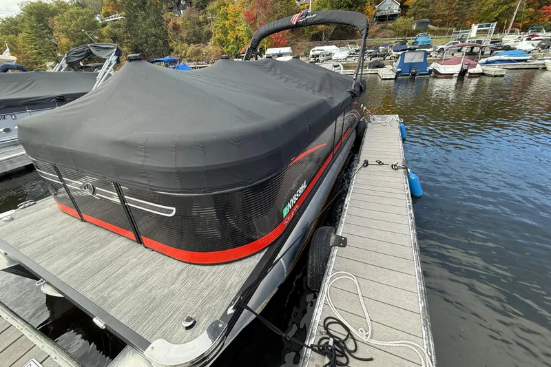 The Image of 2023 Qwest RLS 822 pontoon boat docked with cover, surrounded by autumn foliage. - 0