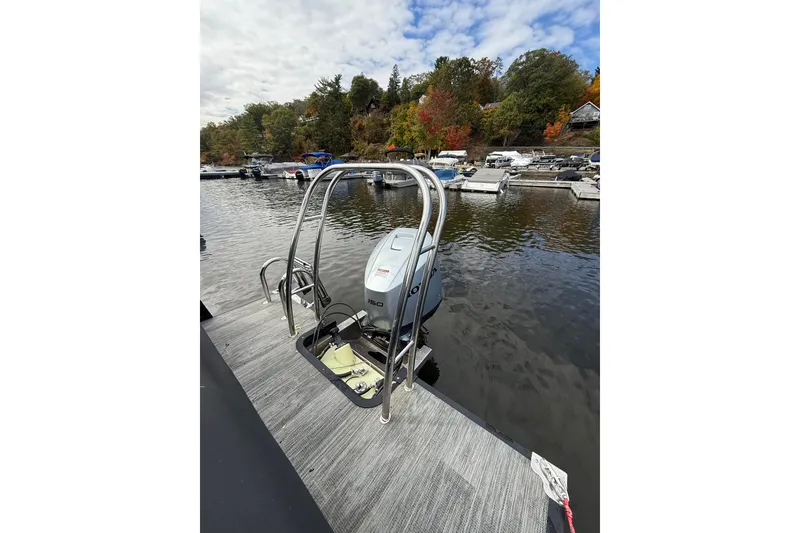 Slide: The Image of 2023 Qwest RLS 822 boat with outboard motor at a scenic lakeside dock. - 3