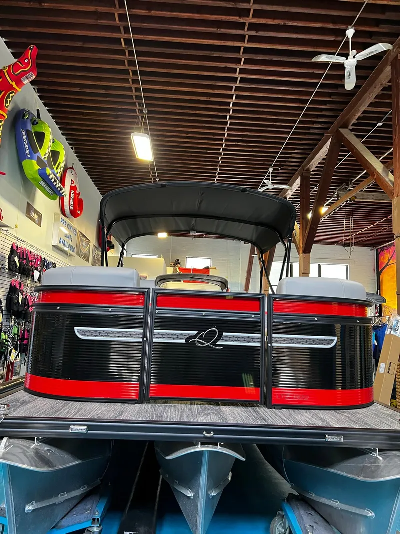 Slide: The Image of 2023 Qwest RLS 822 pontoon boat displayed indoors with vibrant red and black design. - 5