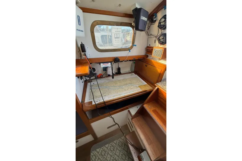 Slide: The Image of Navigation station inside a 1975 Cascade 36 sailboat, featuring maps and instruments. - 10