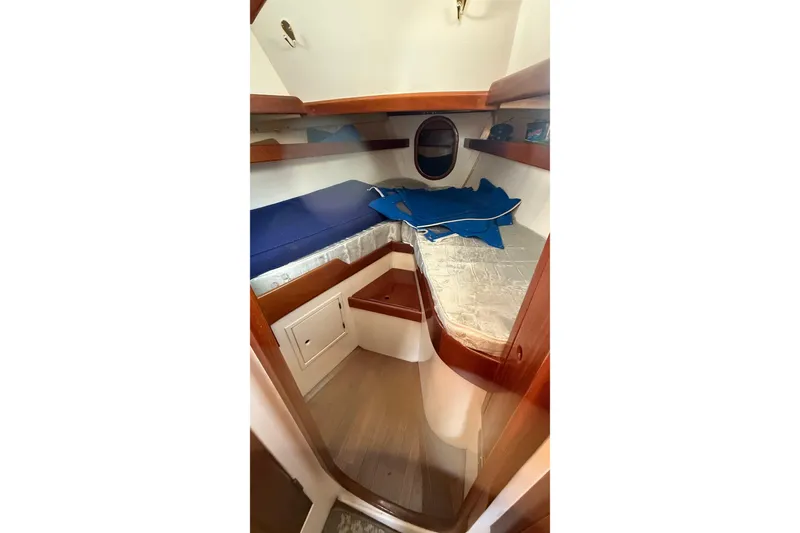 Slide: The Image of Cozy cabin interior of 1975 Cascade 36 sailboat with wooden accents and blue bedding. - 14