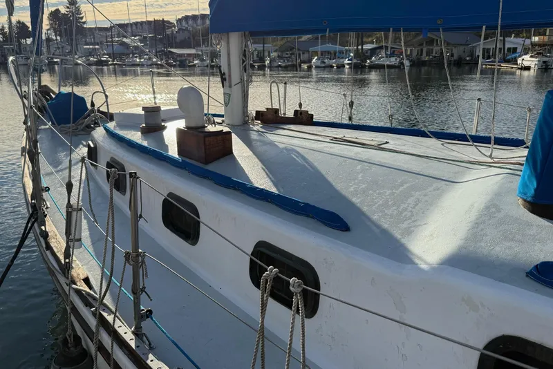 Slide: The Image of 1975 Cascade 36 sailboat docked at marina, featuring blue accents and rigging. - 22
