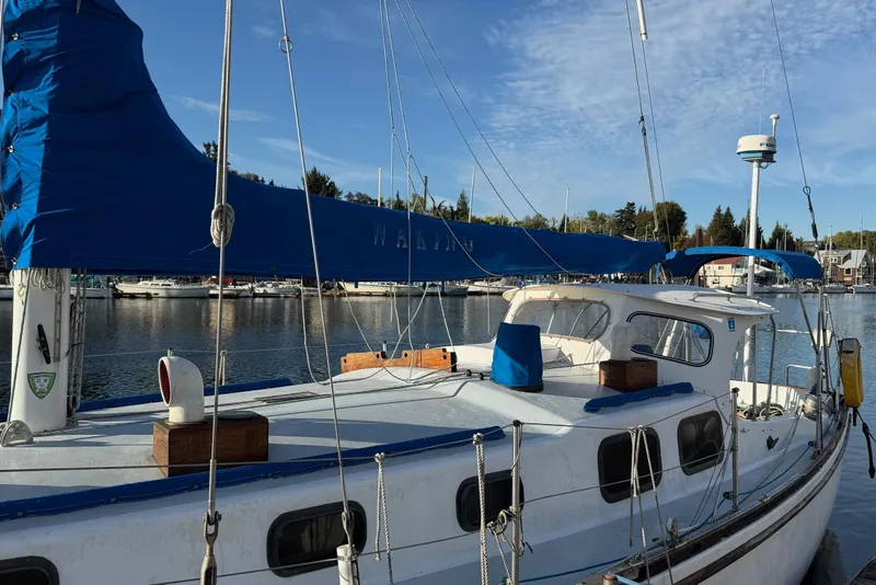 Slide: The Image of 1975 Cascade 36 sailboat docked in a marina, featuring blue sail covers and clear skies. - 23