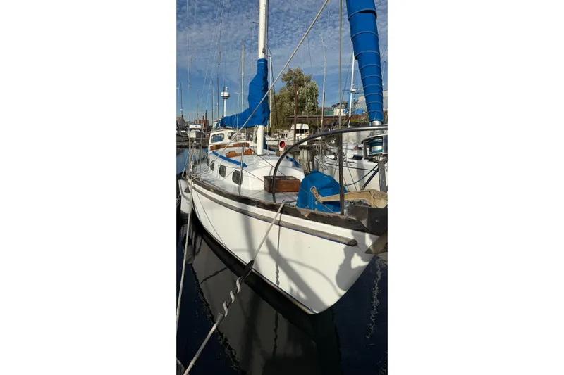 Slide: The Image of 1975 Cascade 36 sailboat docked with blue sail cover, clear sky background. - 25