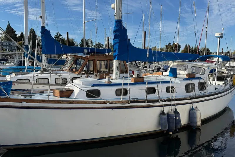 Slide: The Image of 1975 Cascade 36 sailboat docked in a marina, featuring blue covers and wooden accents. - 26