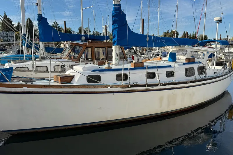 Slide: The Image of 1975 Cascade 36 sailboat docked in marina, featuring blue covers and wooden accents. - 27