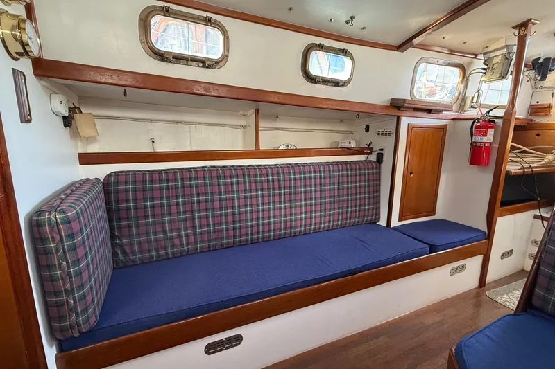 Slide: The Image of Interior of a 1975 Cascade 36 sailboat with plaid seating and wooden accents. - 3