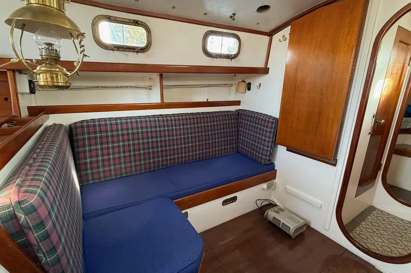 Slide: The Image of Interior of a 1975 Cascade 36 sailboat with plaid seating and wooden accents. - 4