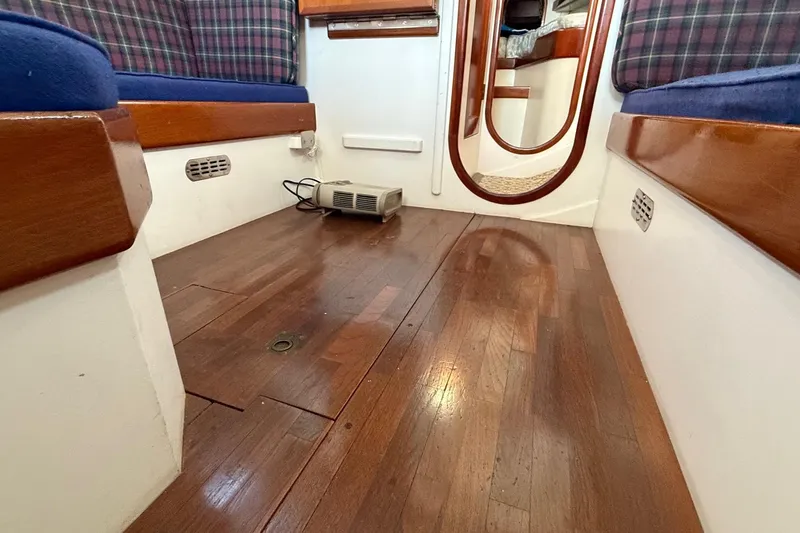 Slide: The Image of Interior of a 1975 Cascade 36 sailboat with wooden flooring and plaid seating. - 6