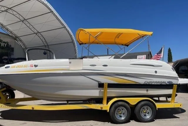 Slide: The Image of 2007 Chaparral Sunesta 232 boat on yellow trailer with canopy, parked outdoors. - 1