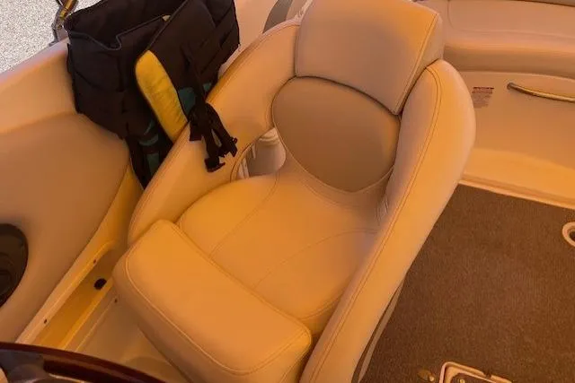Slide: The Image of 2007 Chaparral Sunesta 232 boat interior with beige seating and storage bag. - 3