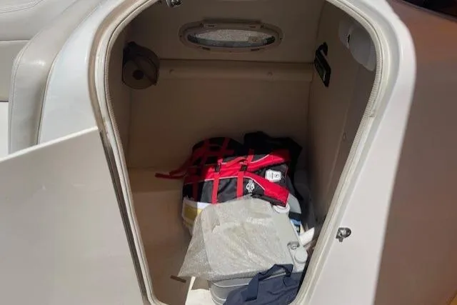 Slide: The Image of 2007 Chaparral Sunesta 232 storage compartment with life jacket and supplies. - 8