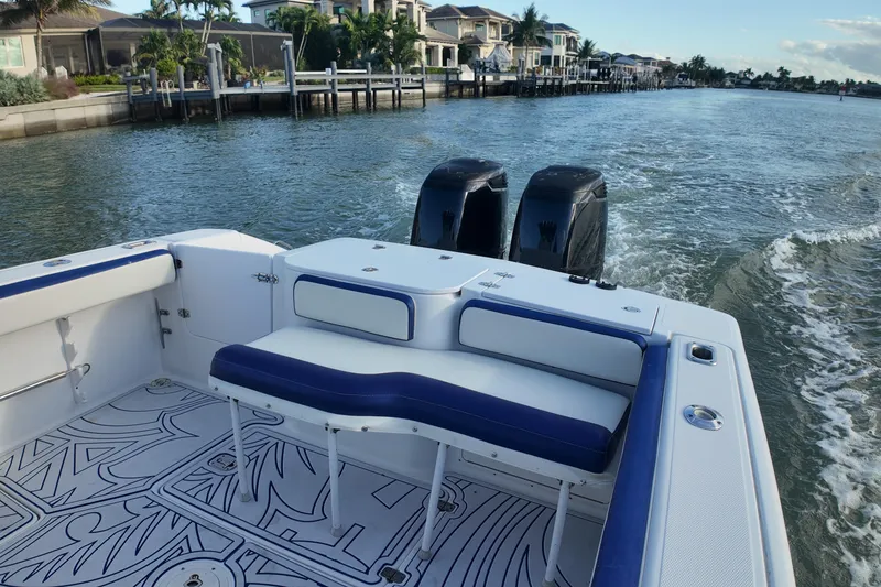 Slide: The Image of 2000 Donzi 35 boat cruising on a scenic waterway with modern homes. - 15