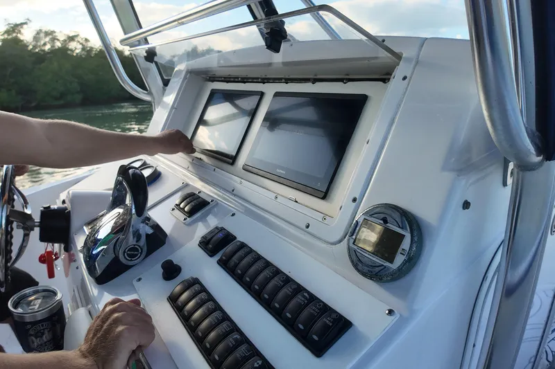 Slide: The Image of Control panel of a 2000 Donzi 35 boat with navigation screens and switches. - 21