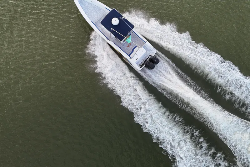 Slide: The Image of Aerial view of 2000 Donzi 35 boat speeding on water, creating dynamic wake patterns. - 32