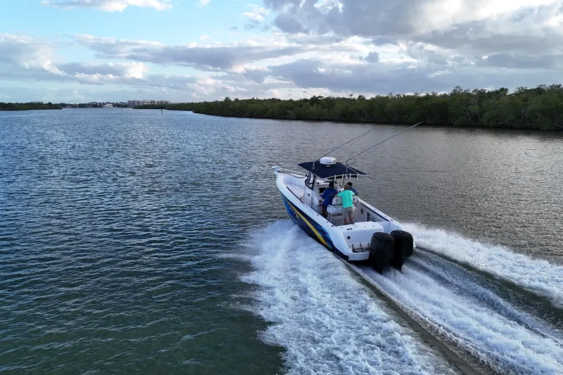 Slide: The Image of A 2000 Donzi 35 boat cruising on a scenic river under a cloudy sky. - 34