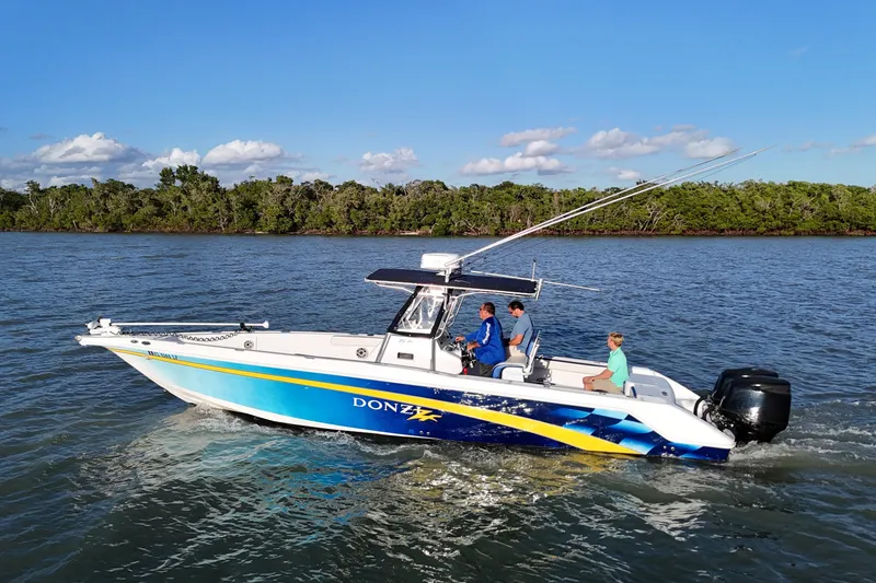 Slide: The Image of 2000 Donzi 35 boat cruising on a scenic river with lush green shoreline. - 4