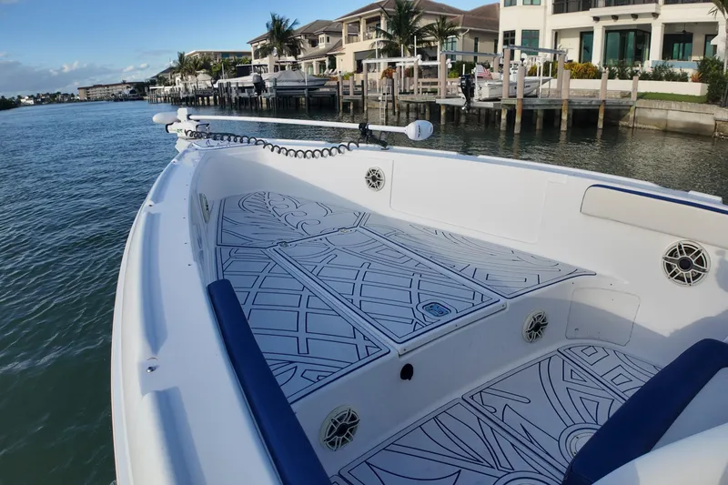 Slide: The Image of 2000 Donzi 35 boat with patterned deck, docked near waterfront homes. - 11