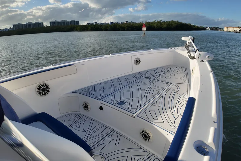 Slide: The Image of 2000 Donzi 35 boat with custom deck design, cruising on calm waters under a partly cloudy sky. - 13