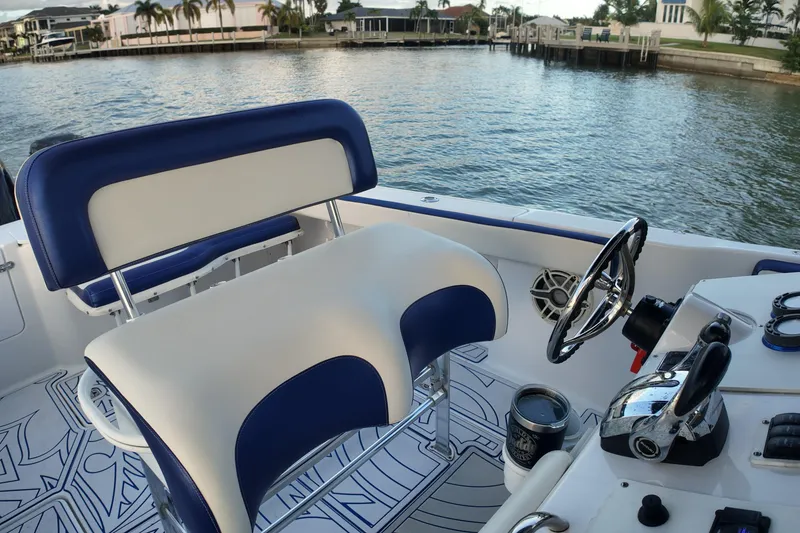Slide: The Image of Interior of a 2000 Donzi 35 boat with blue and white seating, steering wheel, and controls. - 22