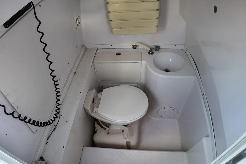Slide: The Image of Compact bathroom in a 2000 Donzi 35 boat, featuring a toilet and sink. - 23