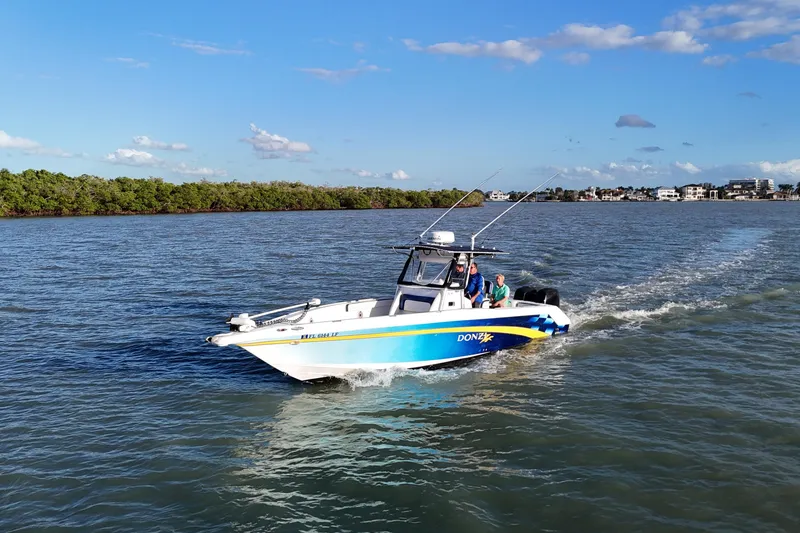 Slide: The Image of 2000 Donzi 35 boat cruising on a sunny day with passengers onboard. - 26