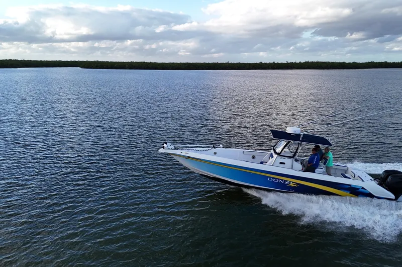 Slide: The Image of 2000 Donzi 35 boat cruising on open water under a cloudy sky. - 28