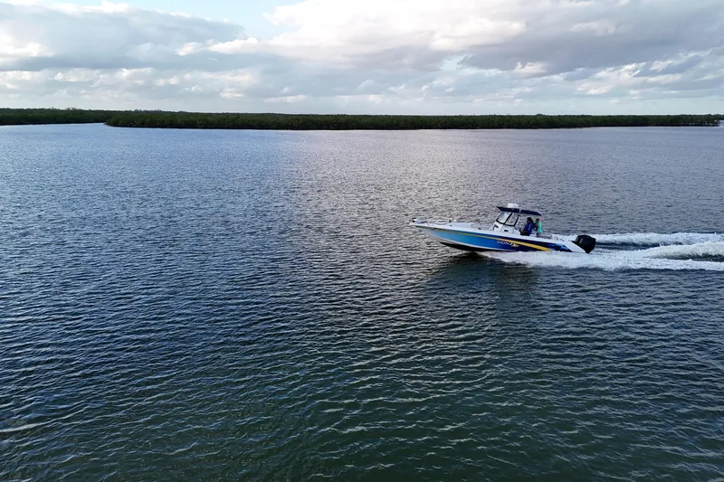 Slide: The Image of 2000 Donzi 35 boat cruising on a calm lake under a cloudy sky. - 29
