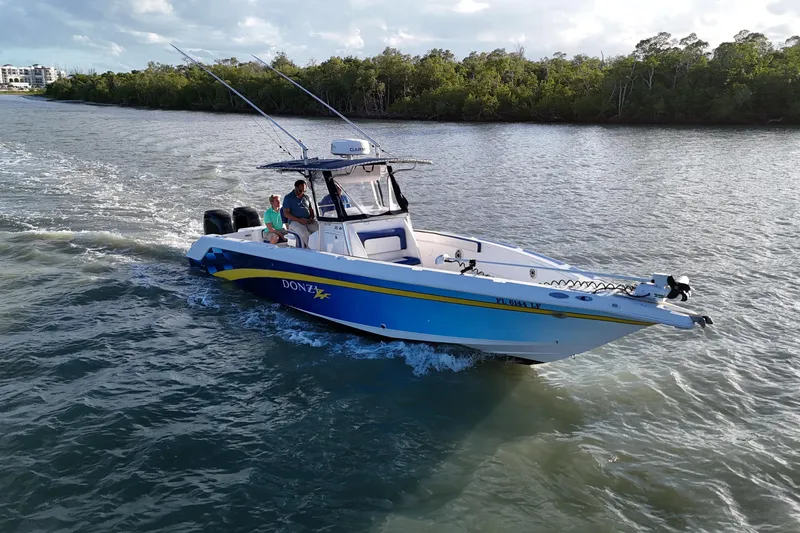 Slide: The Image of 2000 Donzi 35 boat cruising on a scenic waterway with lush greenery. - 3