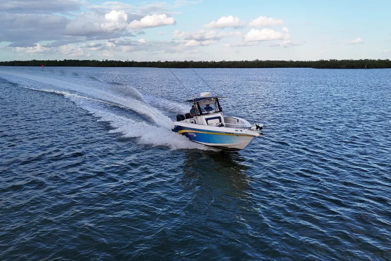 Slide: The Image of 2000 Donzi 35 boat cruising on open water under a clear blue sky. - 30
