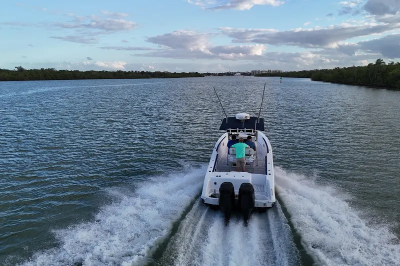 Slide: The Image of 2000 Donzi 35 boat cruising on a scenic river under a blue sky. - 35