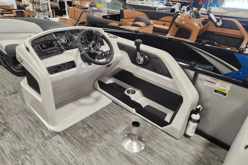 Slide: The Image of 2025 Avalon LSZ Quad Lounger boat interior with steering console and seating area. - 10